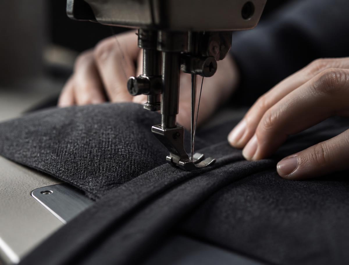 Industrial sewing machine stitching a precise seam on wool fabric